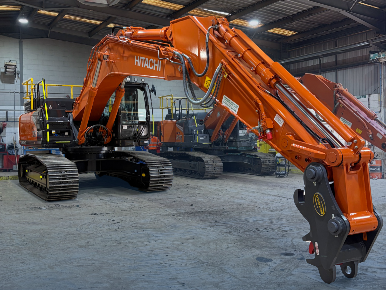 Hitachi ZX350 35-tonne tracked excavator at the Synergy Hire workshop, featuring its hydraulic boom, quick hitch and UK-spec safety handrails.