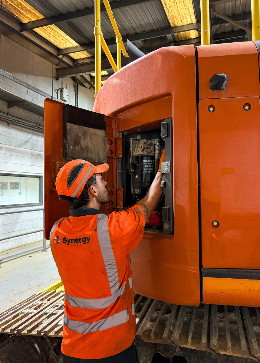 Synergy Hire engineer working on a Hitachi excavator