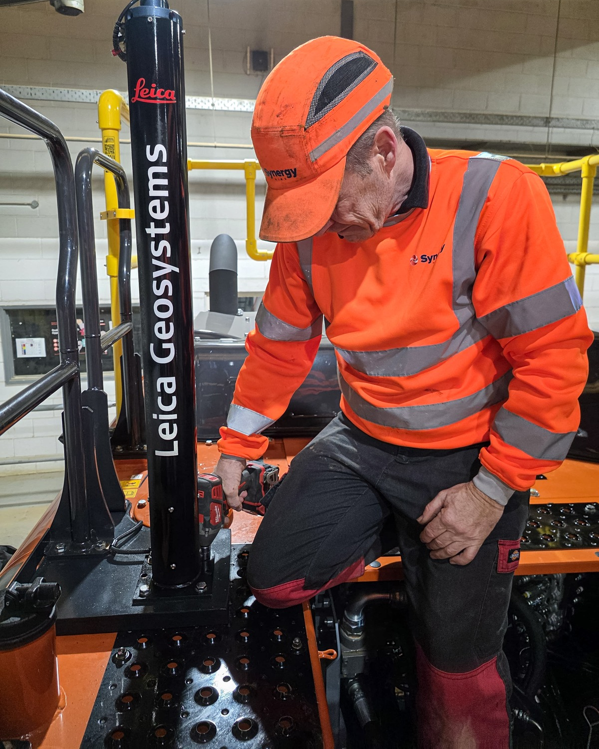 Synergy Hire engineer installing Leica Geosystems equipment on a Hitachi excavator
