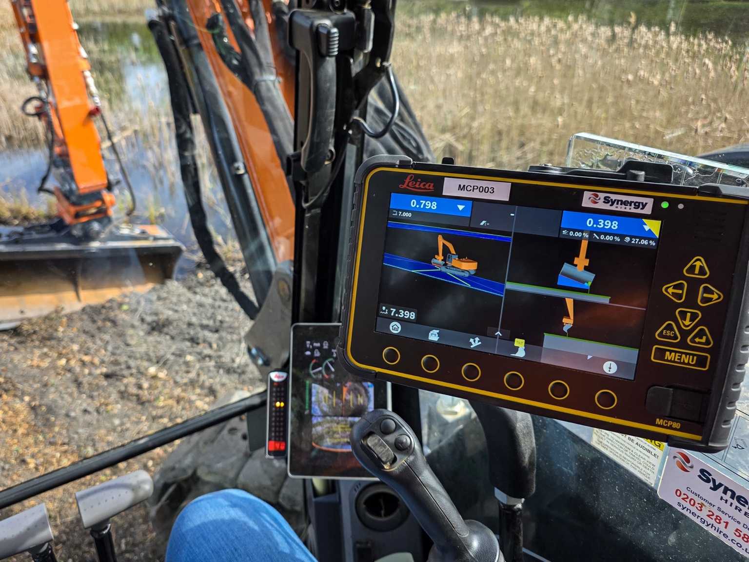 Operator using Leica 3D machine control display inside an excavator cab